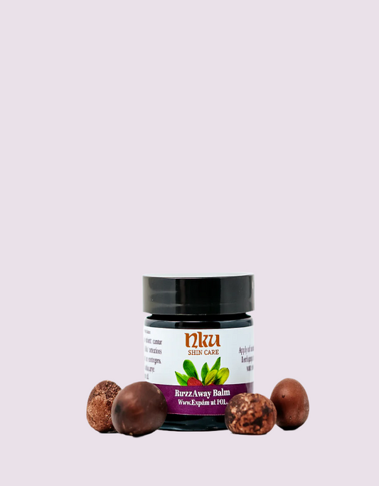 Jar of Nku Skin Care Buzzy Away Balm with shea nuts on a light pink background